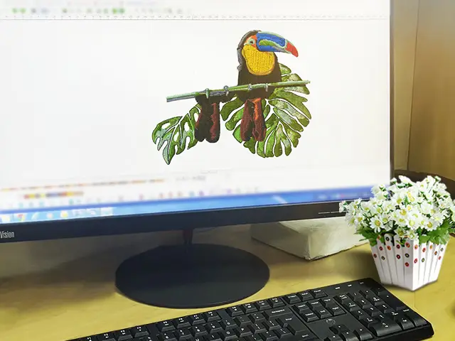 Computer screen displaying a digitized embroidery design of a toucan bird, representing the digitization process for personalized embroidery at Dhaga Raga