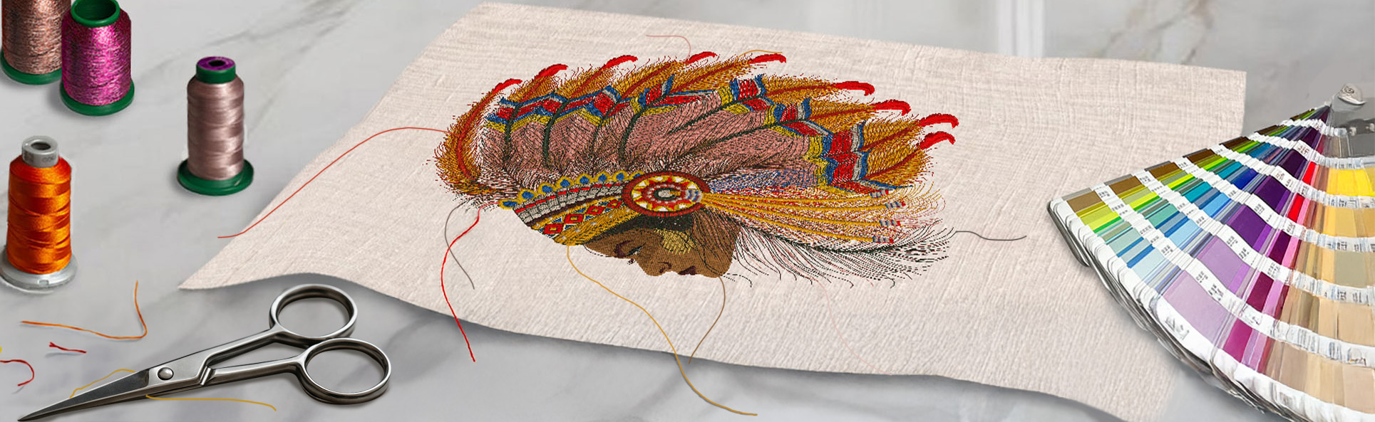 Final finishing stage of embroidery artwork with loose threads, color swatches, and scissors on a marble workspace